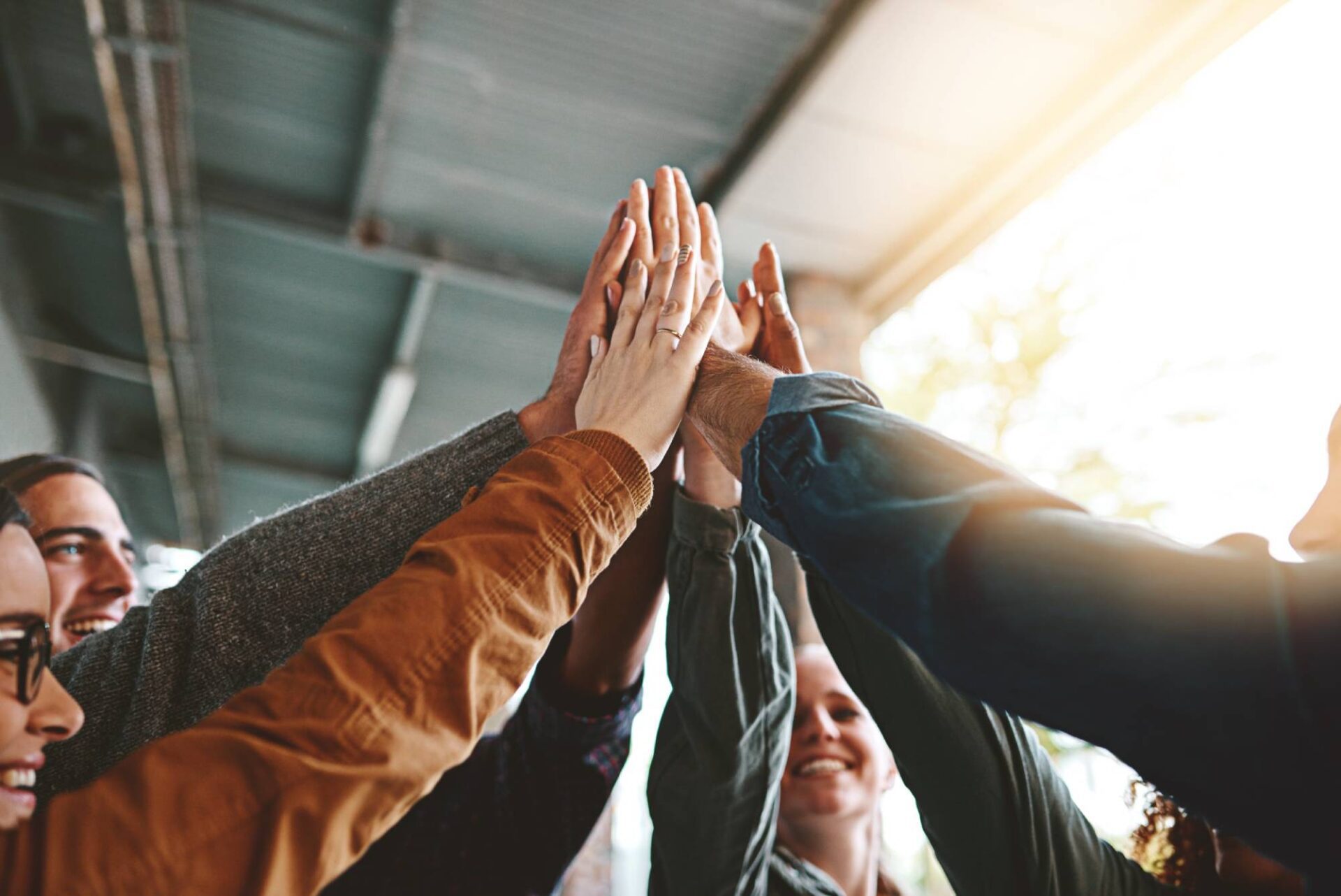 Our Commitment Happy, people and high five for teamwork outdoor with education success, learning achievement and studying. Collaboration, students and celebration for knowledge goals, partnership and university